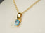 Gold Ocean Breeze Pendant featuring an oval blue topaz gemstone in 18k gold