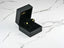 Gold earrings in a black jewelry box, showcasing Peridot Radiance 18k Gold Pear-Shaped design
