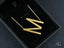Gold letter M earrings shown with personalized initial letter pendant necklace in box chain