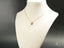 Gold chain necklace with a petite lock padlock pendant on a white bust form