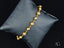 Radiant Elegance 18k solid gold bracelet with spring ring clasp on dark cushion