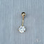 18k gold bellybutton piercing with cubic zirconia gemstone on a gray background.