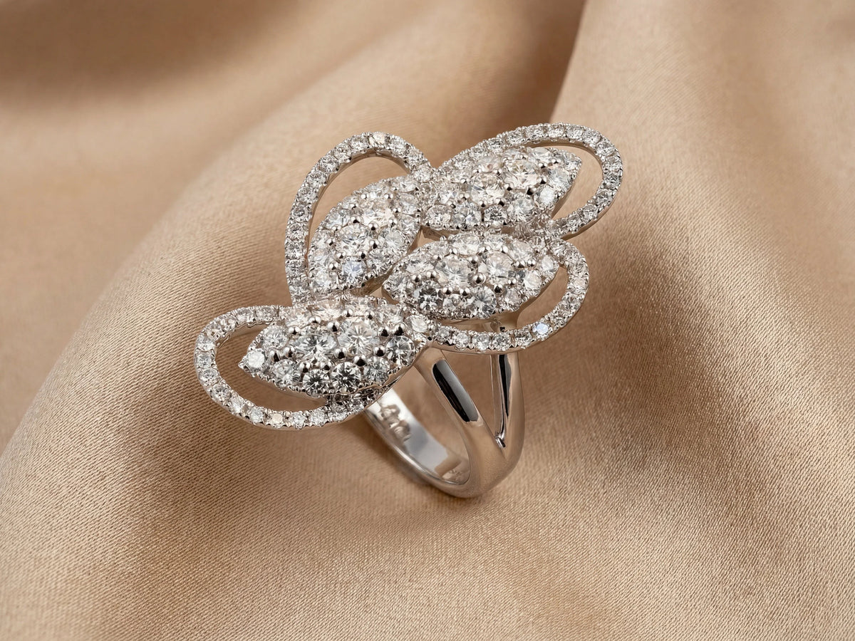 Angled view of 18K white gold diamond statement ring on champagne silk - ArtGold Jewelry