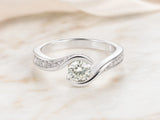 Angled view of bypass diamond ring showing twist design and pavé accents