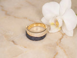 Angled view of Sophisticated contrast 18K gold overlapping ring with white CZ band atop black CZ band