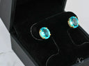 Azure Embrace earrings with oval blue topaz in gold halo box