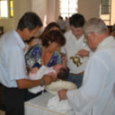 A baby being baptized by a priest.
