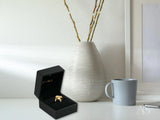 Open black jewelry box with Blossom Charm 18k gold ring and diamond centerpiece