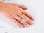 Woman’s hand with Blossom Charm 18k Gold Ring with Diamond Centerpiece and French-tipped nails