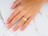 Womans hand with braided eternity comfort fit gold band ring
