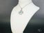 Silver-tone celestial cross necklace with light blue topaz and diamond accents in art gold jewelry style