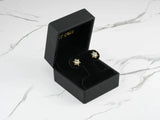 Open Celestial Glow 18k gold blue topaz stud earrings in black box