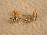 Celestial Glow 18k gold blue topaz stud earrings with oval gem and spikes