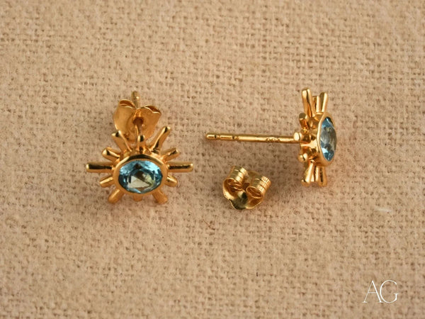 Celestial Glow 18k gold blue topaz stud earrings with oval gem and spikes