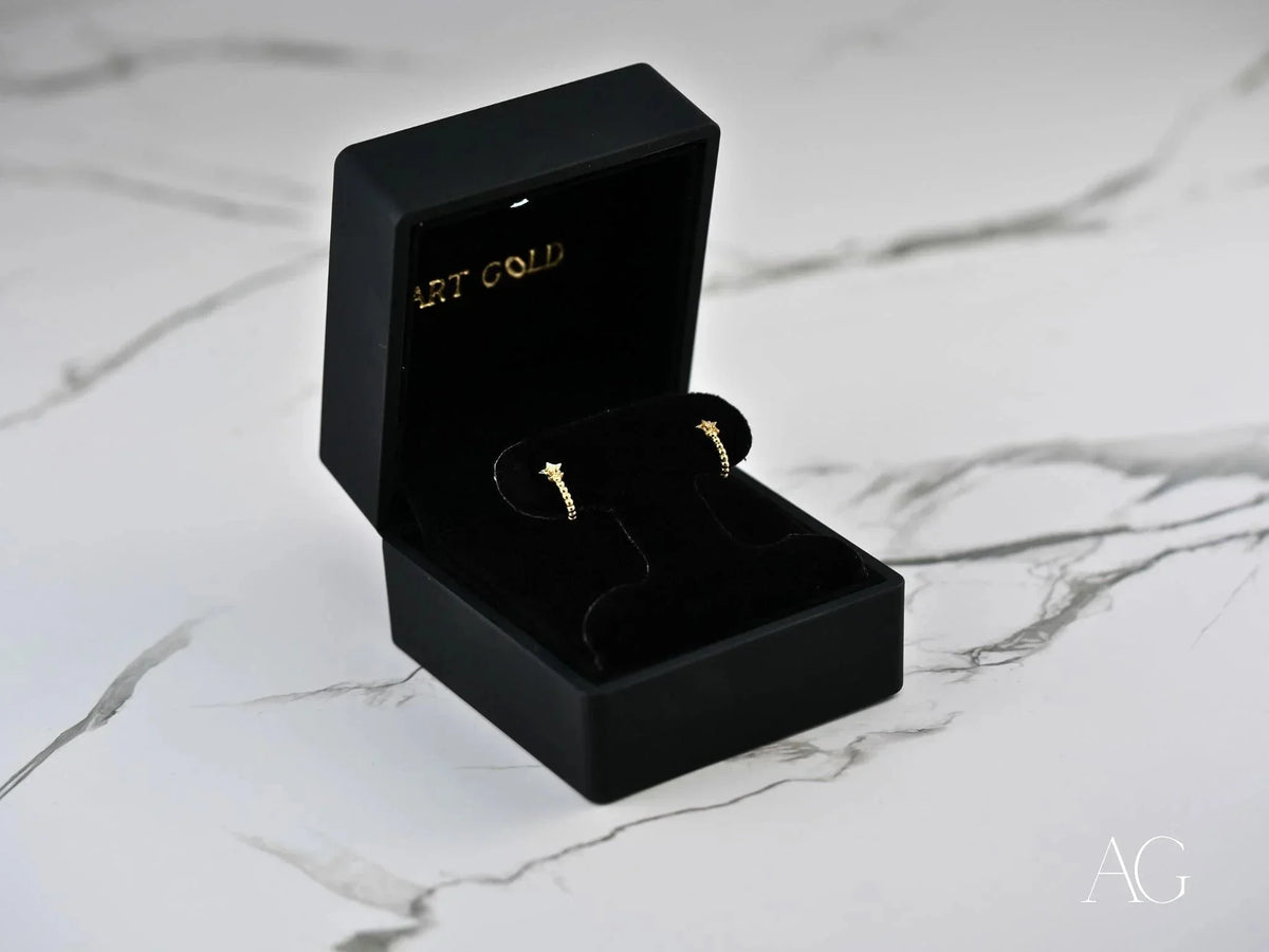 Black velvet box displays Celestial Glow 18k gold star earrings