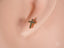 Gold cross earring with dark gemstones from Celestial Grace 18K gold cross jewelry collection