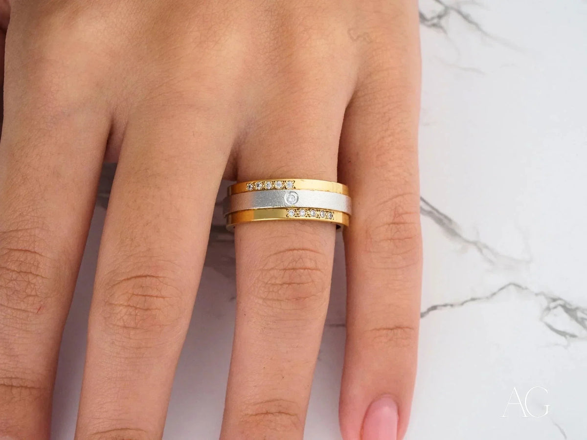 Two-tone gold wedding band with diamond accents, side view showing yellow borders and white center