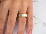 Two-tone gold wedding band with diamond accents, side view showing yellow borders and white center