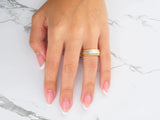 Two-tone gold wedding band with diamond accents, top-down view showing stone settings