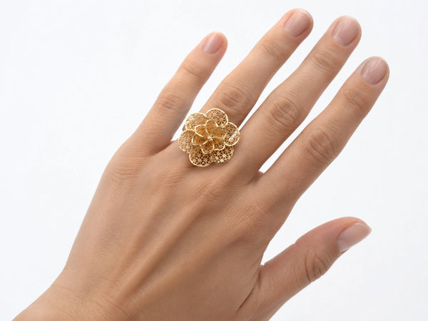 Close-up view of 18K gold flower ring featuring intricate openwork lattice petal design