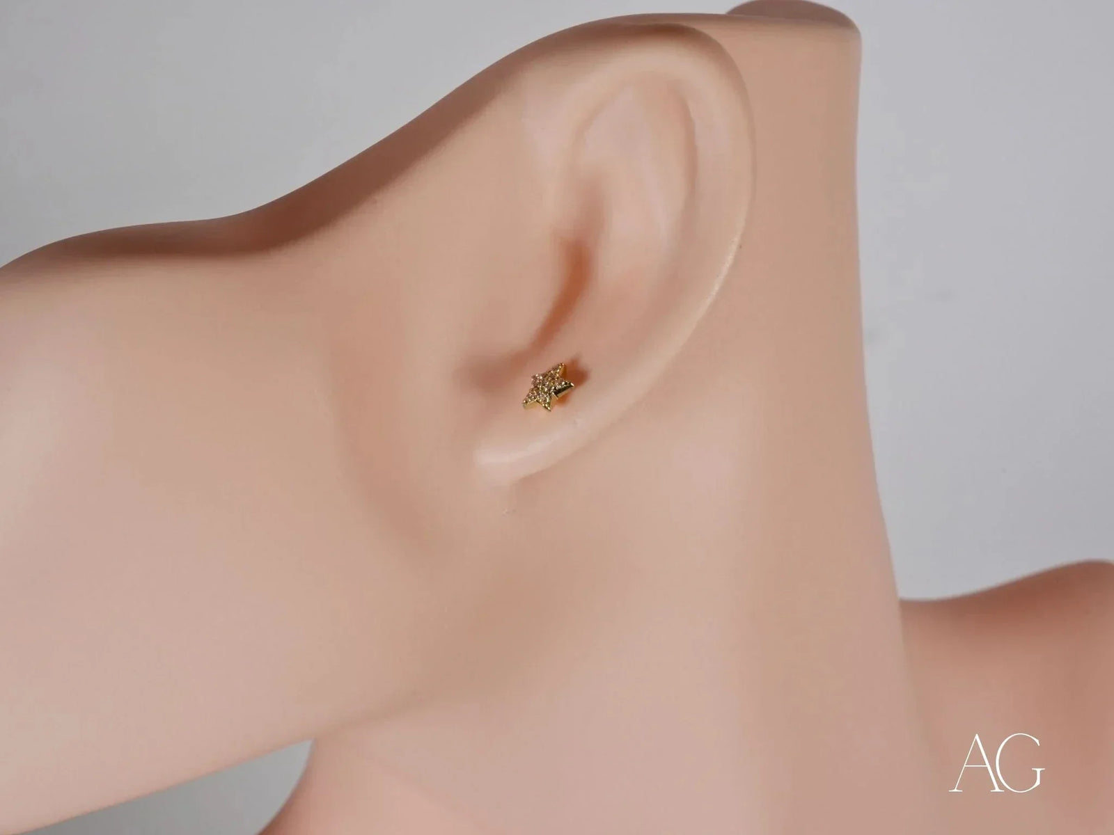 Gold star earring in certified 18k solid art gold jewelry on ear