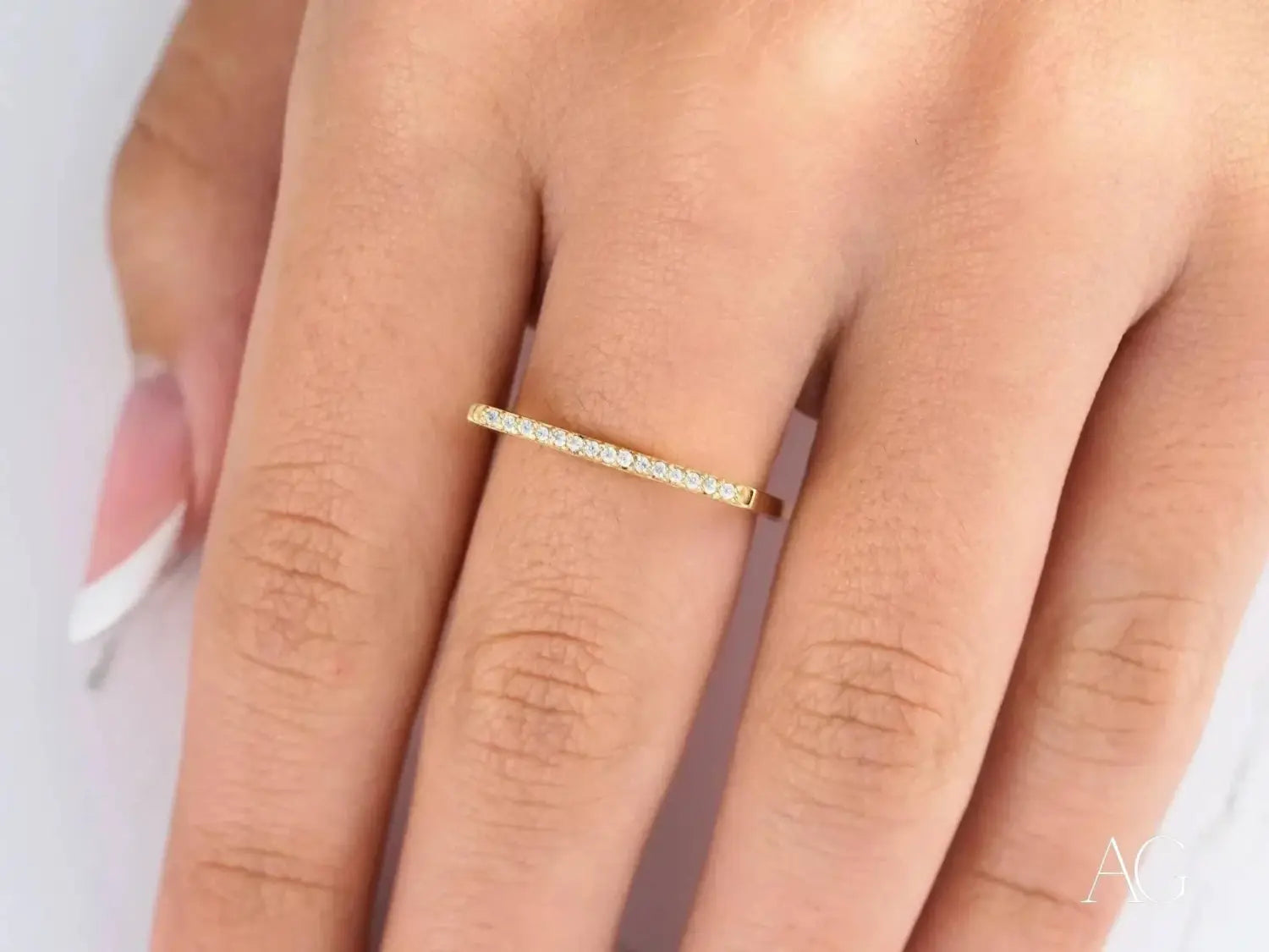 A pair of silver wedding bands with a central diamond engagement ring and a smooth band in modern heirloom style.