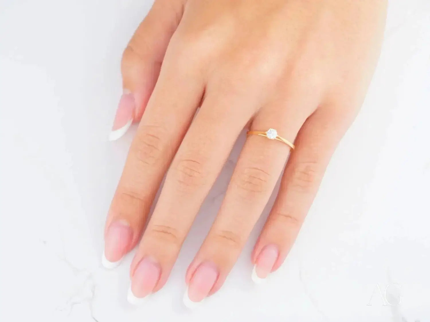 Delicate art gold jewelry engagement ring with round-cut clear gem.