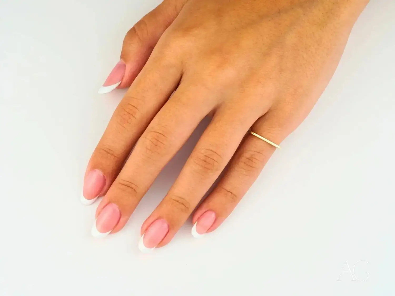 Delicate 18k gold band ring from royal jewels on index finger