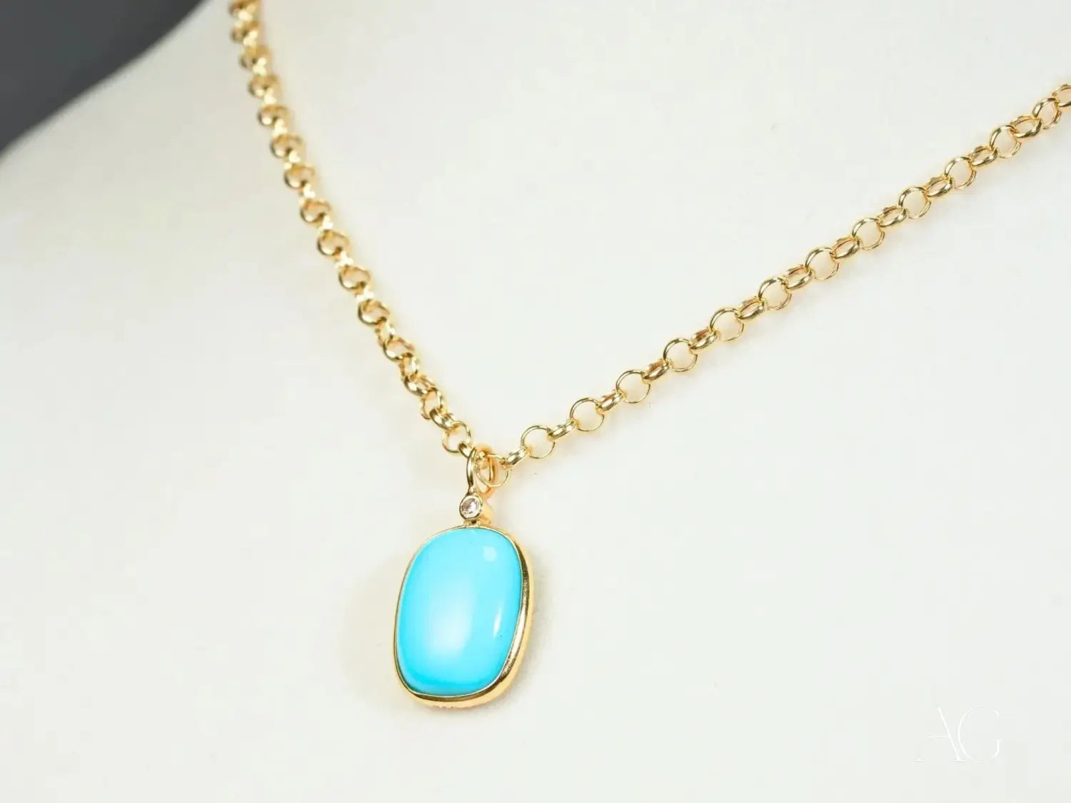 a delicate fine jewelry gold necklace featuring an 18k gold chain with a vibrant turquoise oval pendant and polished finish in a handmade gold jewelry design