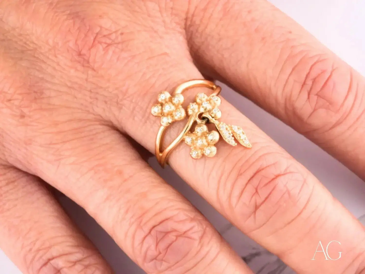A delicate 18k gold ring featuring a floral design with clustered pearl-like beads and small diamond accents showcasing elegant fine jewelry craftsmanship.