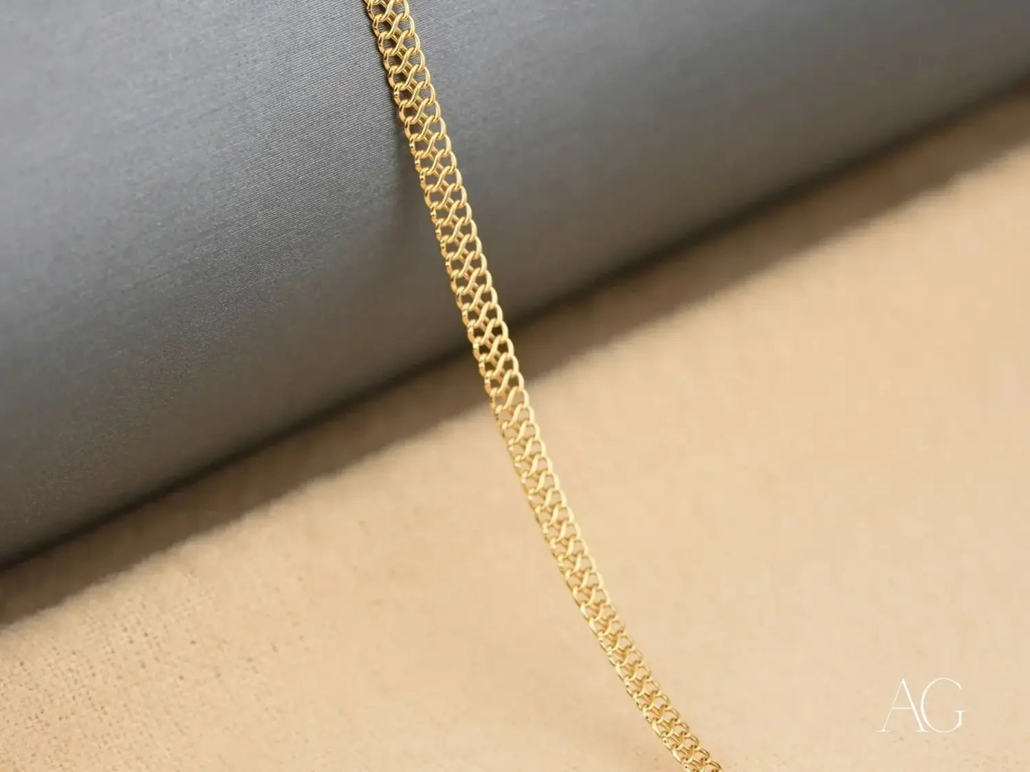 A delicate gold-toned chain with a fine interlocking link design showcasing the craftsmanship of art gold jewelry at your local Everett jeweler.