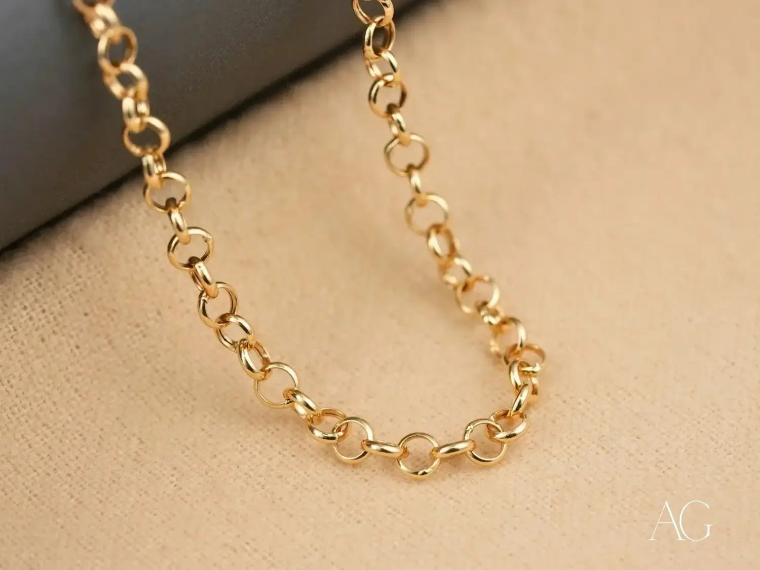 a delicate gold jewelry chain featuring interlocking oval links crafted from polished 18k gold metal, exemplifying fine jewelry in ancient designs.