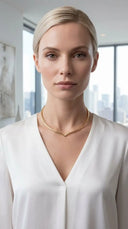 A delicate gold-toned v-shaped necklace worn against a white blouse.