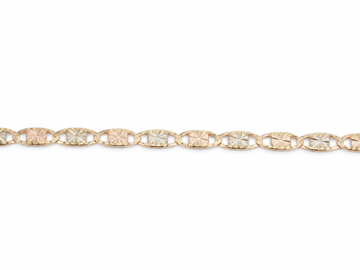 Detail of the diamond-cut rosette plates alternating rose and white gold inside yellow gold frames