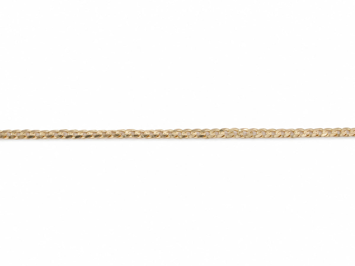 14K yellow gold Cuban chain laid flat, interlocking curb links catching the light