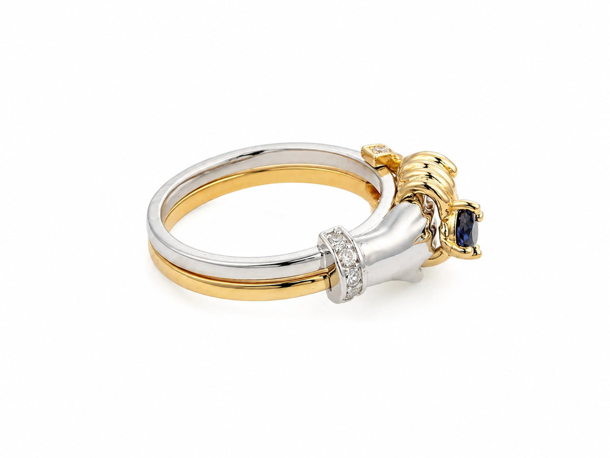 Detailed side view of sculpted hands and sapphire setting on two-tone gold band