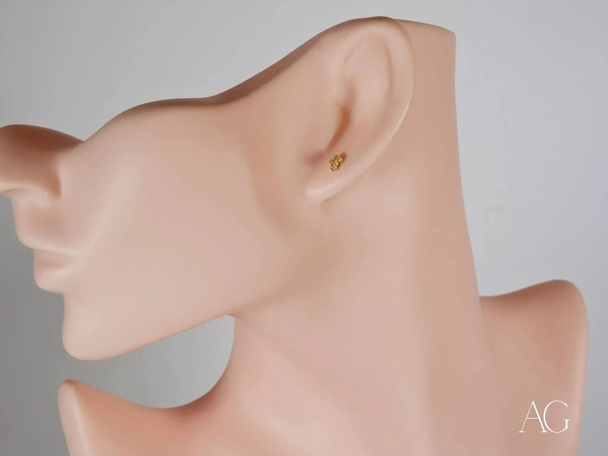 Golden diamond cross earring in certified 18k solid gold on mannequin ear