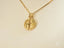 Gold two faces pendant from Dual Harmony art jewelry featuring a round split design