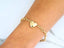Elegant 18k gold heart bracelet with three delicate heart charms and a shiny puffed heart