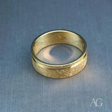 Elegant 18k gold diamond wedding band with textured gold and polished rim