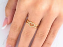 Elegant 18k yellow gold heart ring with clear stones on finger