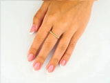 Elegant 18k yellow gold square shape ring on woman’s hand with French manicure