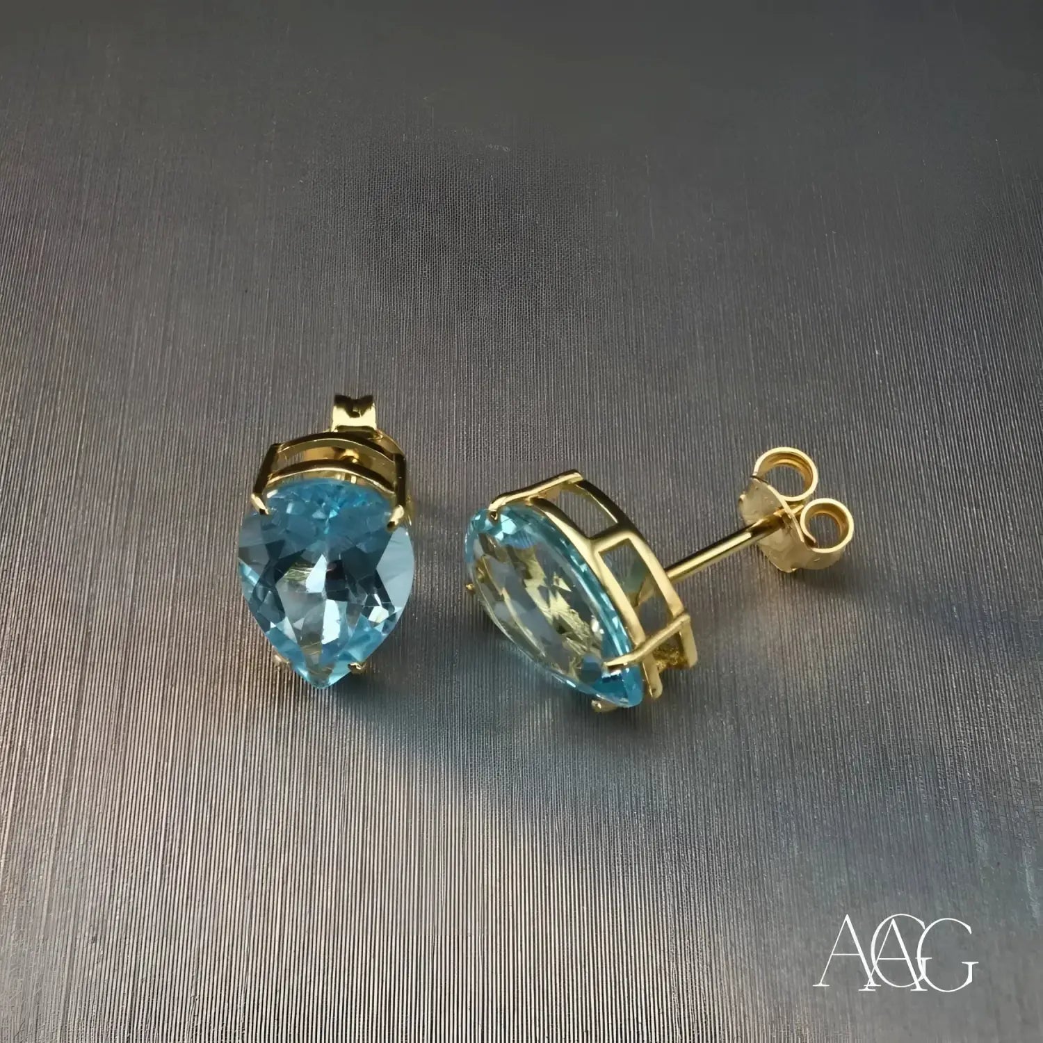 A collection of gold jewelry featuring fine jewelry designs with pearl accents and a sunburst gold art piece.
