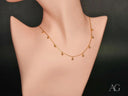 Elegant 18K gold beaded necklace with delicate chain and dangling beads