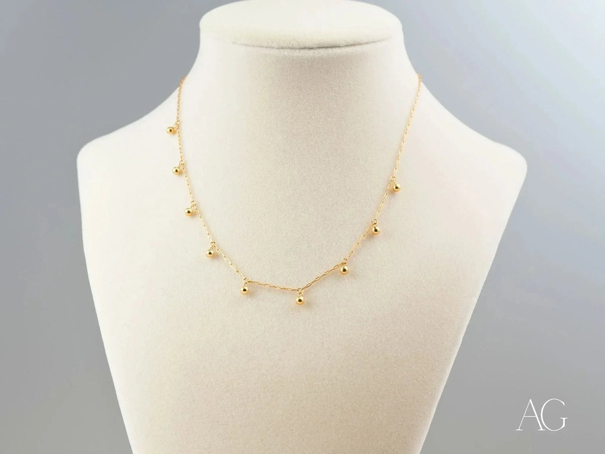 Elegant 18K gold beaded necklace with delicate spherical charms