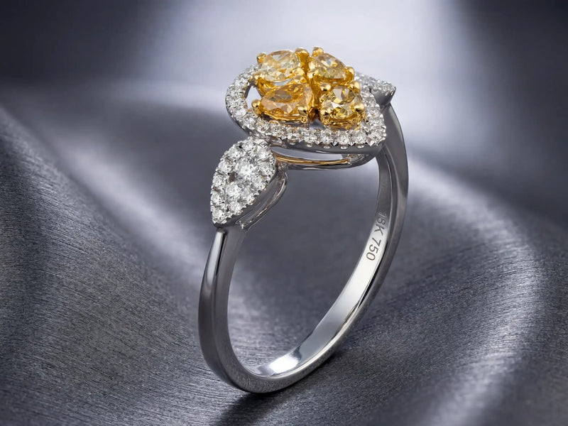 Elegant yellow diamond ring with a floral design, featuring four central stones surrounded by smaller white diamonds and accented with pear-shaped diamond details on the band.
