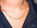 18k gold rope chain necklace on a person, timeless elegance