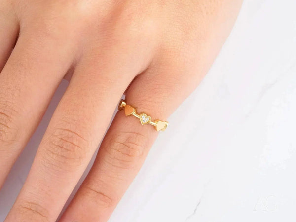 Elegant 18k yellow gold CZ heart ring with diamond-encrusted hearts on finger