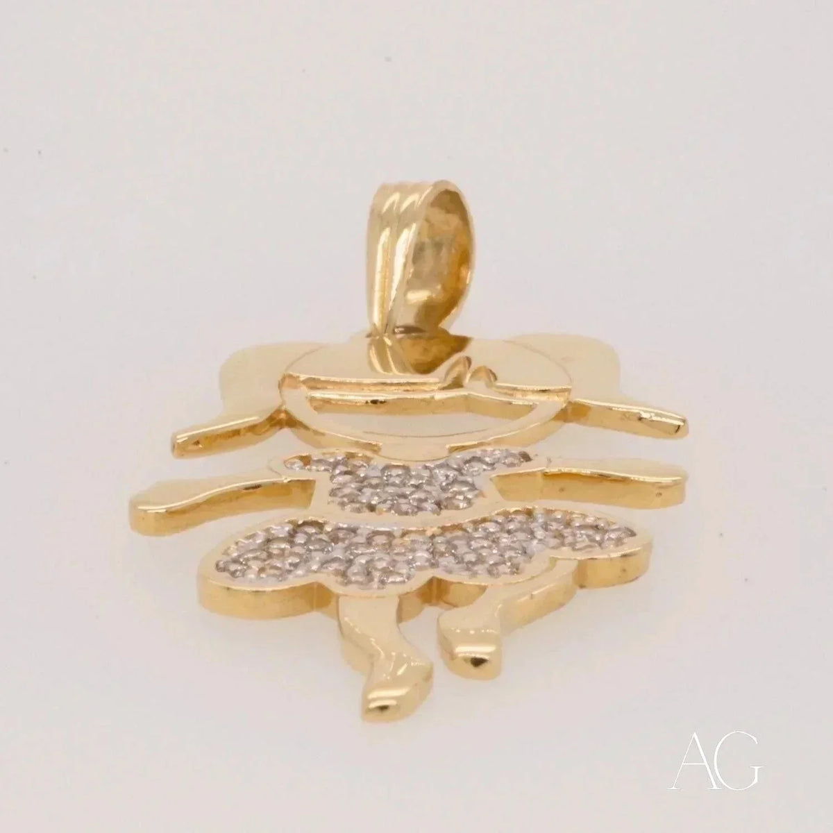 Low-angle view of Enchanting 18K gold Girl doll pendant with CZ dress