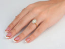 Woman’s hand with Eternal Halo Engagement oval diamond ring and French tips